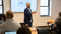 Instructor teaches a class with graphs on the projector
